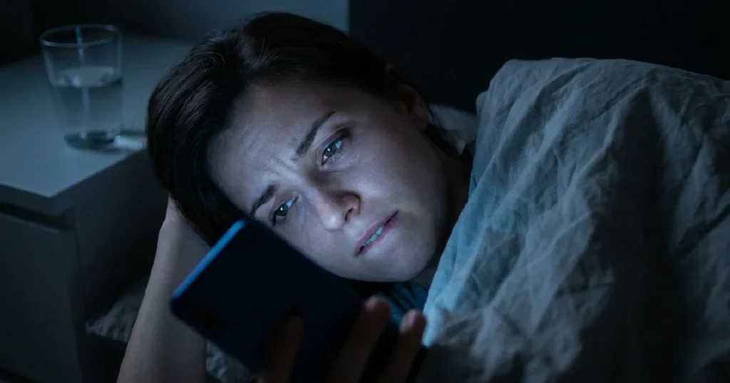 Woman Experiencing Social Media Anxiety and Phone Jealousy in Bed