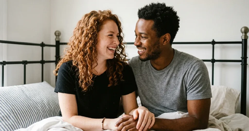 Couple laughing together on bed
